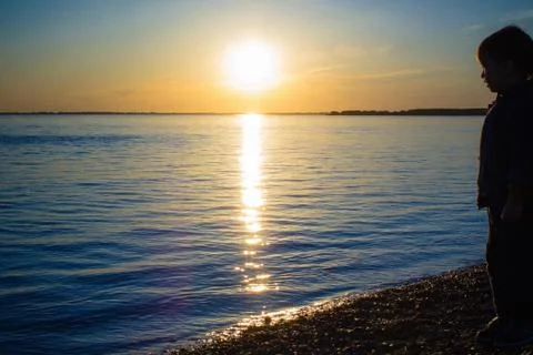 Sunset, sea, boy. Stock Photos