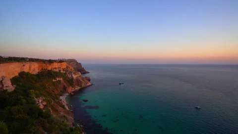 Sunset on the sea coast, video from above, view of the azure sea and quiet ships Stock Footage 142399593