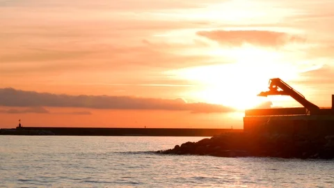 Sunset by the sea with cranes in the background. Vidéo 102874684