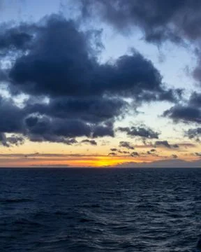 Sunset at sea with mountains in the background Stock Photos