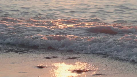 Sunset at sea, sandy beach with pebbles, sun reflection in water, waves Stock Footage 111506883