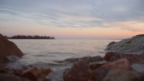 Sunset at sea. Stony beach at evening. Gulf of Finland, view from the dam Spring Stock Footage 128170833