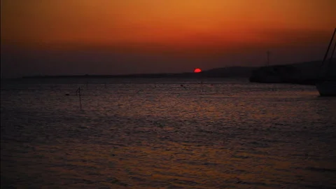 Sunset on the sea The sun goes below the horizon It gets dark Stockbeeldmateriaal 150250878