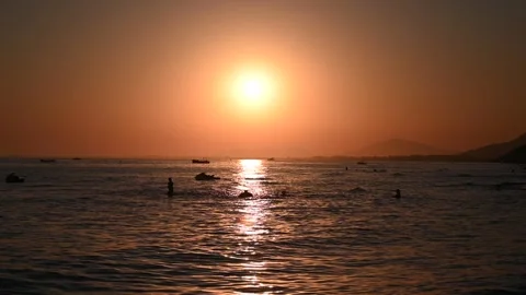Sunset on the sea. Tourists are swimming in the sea. Stock Footage 313907053