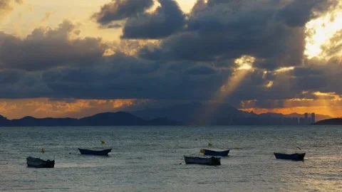 Sunset Sea Tyndall Effect Dramatic Crepuscular Rays Boats Handheld Video stock 347995683