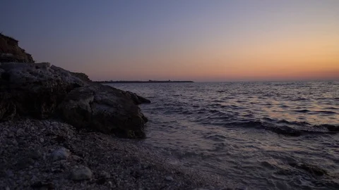 Sunset at sea. Waves breaking, crushing and splashing on the rocks on sea coast. Stock Footage 114317377