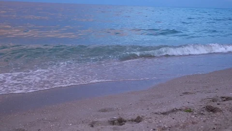 Sunset at sea, waves, sea breeze beach. waves wash away traces of people . Stock Footage 92545178