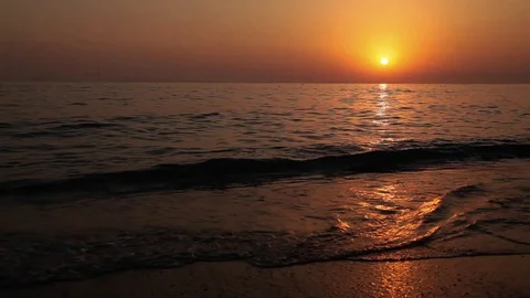 The Sunset on the sea. A waves upon the sand Stock Footage 125781842