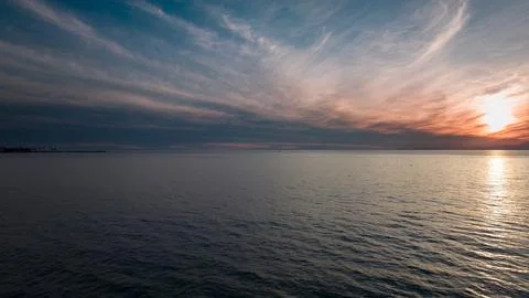 Sunset seascape. The red sun setting among the clouds. blue sky Stock Photos