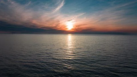 Sunset seascape. The red sun setting among the clouds. blue sky Stock Photos