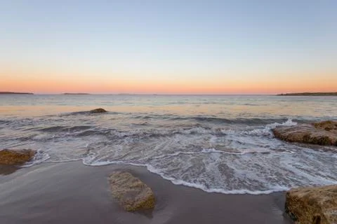Sunset seascape with rocks in foreground Stock Photos