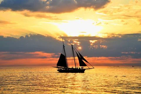 Sunset seascape with a sailboat. Stock Photos