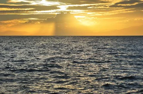 Sunset seascape, sun rays through the clouds Stock Photos
