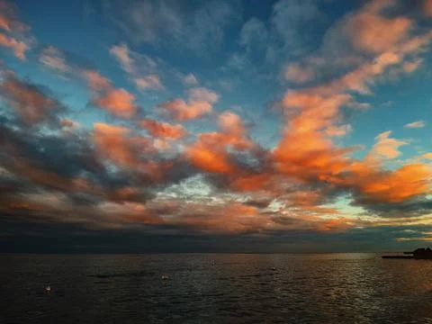 Sunset on the seashore with orange-red clouds Stock Photos