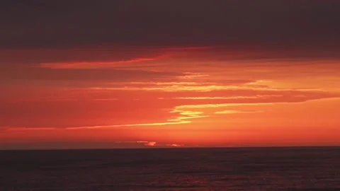 A sunset that seems painted and scratched with a yellow brush over the sea with Vidéo 195125546