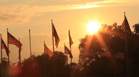 Sunset sends flares over the flags Stock Footage 8776010