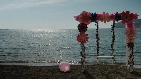 At sunset at the shore stand a swing with decorations and a ball Stock Footage 74692599
