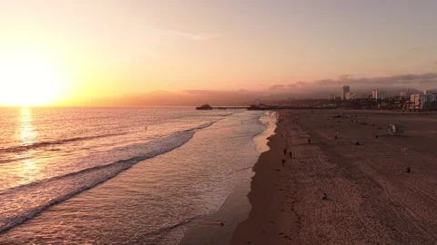 Sunset Shoreline Flight Toward Santa Monica Pier and Beachgoers Vídeos de archivo 332327554