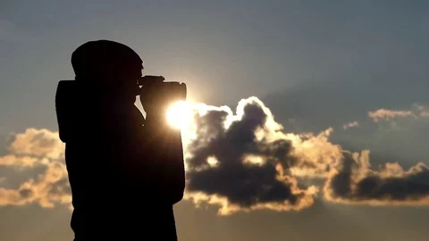 Sunset is Shot by a Beautiful Woman With a Professional Camera Standing in Stock Footage