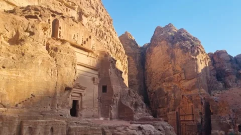Sunset shot over an ancient Nabataean tomb in Petra, Jordan, carved into Stock Footage 337549970
