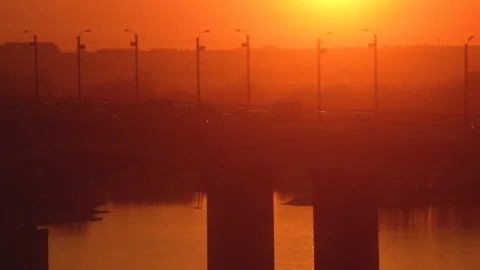 Sunset silhouette of bridge over the river with city transport traffic Stock Footage 130238545