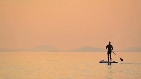 Sunset Silhouette of Man on Stand up paddle board surfing. Paddle-board Stock-Footage 99181512