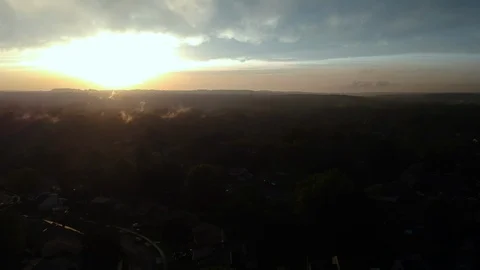 Sunset silhouette as rain falls over a suburban neighborhood Stock Footage 98196103