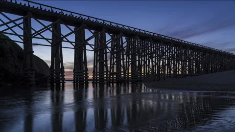 Sunset at silhouetted Pudding Creek Bridge with reflection - Timelapse Stock Footage 219349715