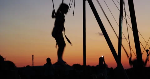 Sunset silhouettes of kids jumping in trampoline Stock Footage 337907108