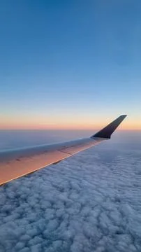 Sunset sky on airplane, plane window, evening flight for relax in holiday Stock Photos