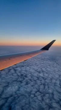 Sunset sky on airplane, plane window, evening flight for relax in holiday Stock Photos