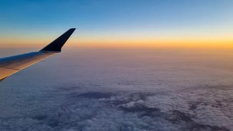 Sunset sky on airplane, plane window, evening flight for relax in holiday Stock Photos