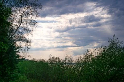 Sunset sky background with clouds. The beauty of clouds over the sea at dusk. Stock Photos