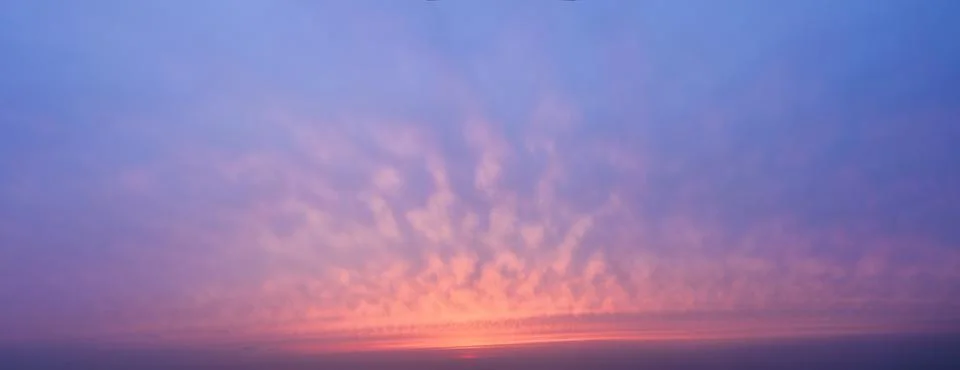 Sunset sky background with clouds. Panoramic view. Stock Photos