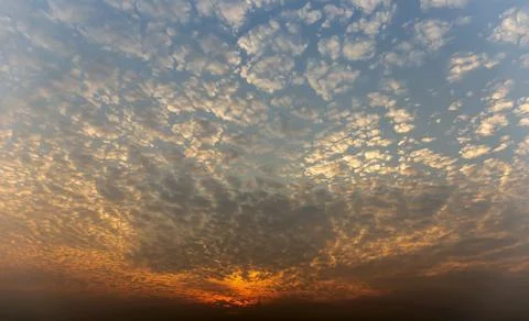 The sunset sky is beautiful in orange, the clouds spread into cubes. Stock Photos