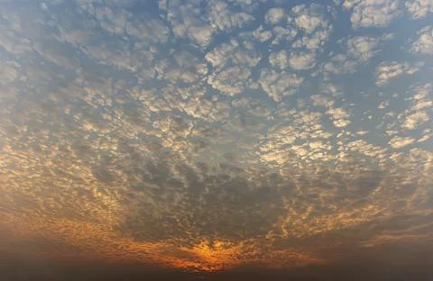 The sunset sky is beautiful in orange, the clouds spread into cubes. Stock Photos