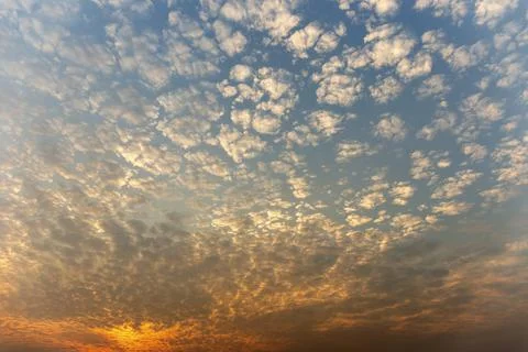 The sunset sky is beautiful in orange, the clouds spread into cubes. Stock Photos