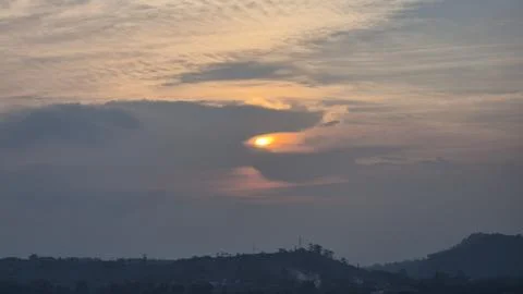 A sunset sky behind clouds with a sun Stock-Fotos