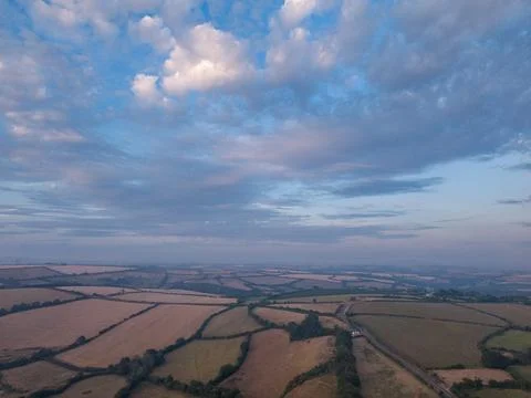 Sunset sky with clouds and mist over agricultural fields in Looe, Cornwall Stock Photos
