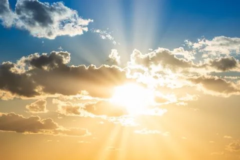 Sunset sky with clouds and sun Stock Photos