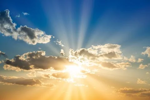 Sunset sky with clouds and sun Stock Photos