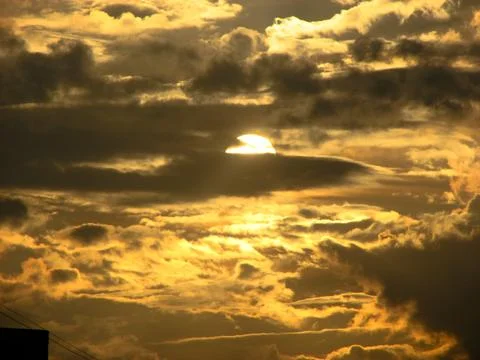 Sunset sky with clouds and sunbeams. Beautiful nature background. Stock Photos