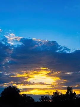 Sunset sky with clouds over trees in a peaceful evening Stock Photos