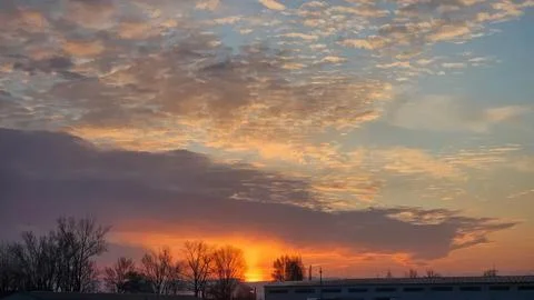 Sunset sky with colorful clouds over a rural landscape Stock Photos