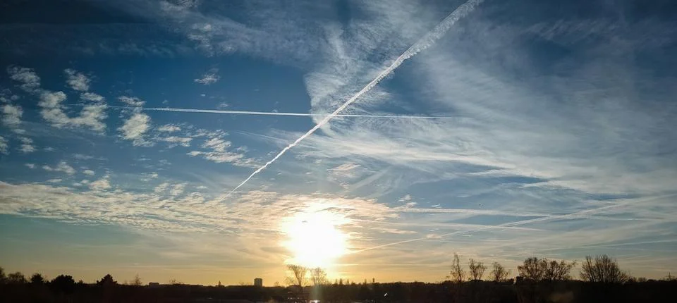 Sunset Sky with Contrails and Dramatic Cloudscape Stock Photos
