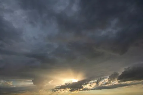 Sunset sky covered with dramatic storm puffy clouds before rain. Stock Photos
