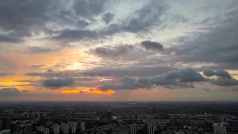 Sunset sky with dramatic clouds over a sprawling urban cityscape at dusk Video stock 347065149