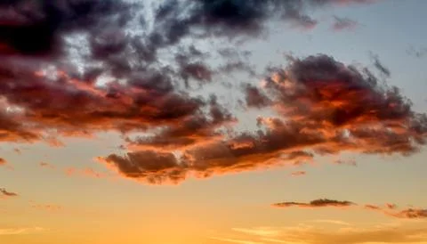 Sunset sky with dramatic orange clouds Stock Photos