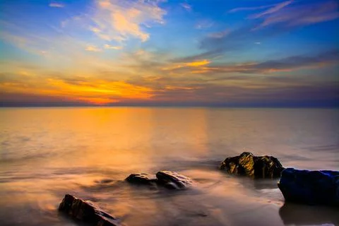 Sunset sky with dramatic sunset clouds over the sea. Beautiful sunrise over O Stock Photos
