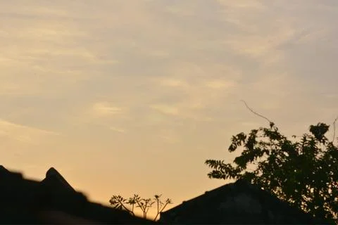 Sunset sky featuring cloud iridescence and dark silhouettes 库存照片